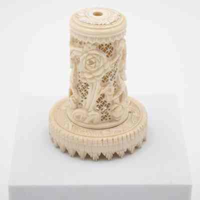 Carved round ivory box on ivory base with ivory lid.: Up close image of the ivory circular carved box. It is engraved with roses and leave details.