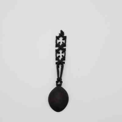 Back of ebony wood spoon: The image features an intricately carved ebony wood spoon against a plain white background.