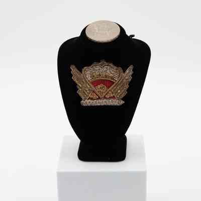 Crown pin: The red and silver crown pin, handmade in India, features intricate embroidery, symbolizing its regal presentation to Mrs. Jordan by Queen Elizabeth II.