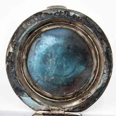 Inside of compant: A tarnished silver compact shows engravings of "Jessie Jordan" and "Kuwait."