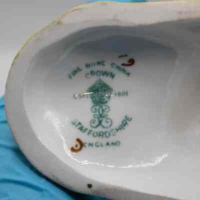 Writing on bottom of figurine: Green writing reads, "Fine bone china; crown est. 1801. Staffordshire, England."