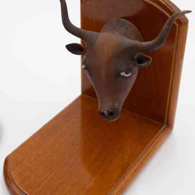 Second Book End: Image of a wooden bookend with a bull head. White eyes are painted on the bull head.