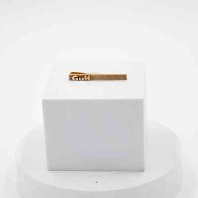 Golf "Gulf" tie bar: A thin rectangular tie bar with the word "Gulf" in thick, protruding text.