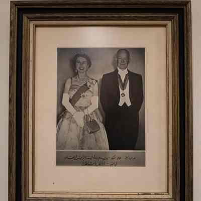 Elizabeth II and Eisenhower photo in a wood frame.: Framed photograph of Queen Elizabeth II and President Dwight D. Eisenhower with Arabic script