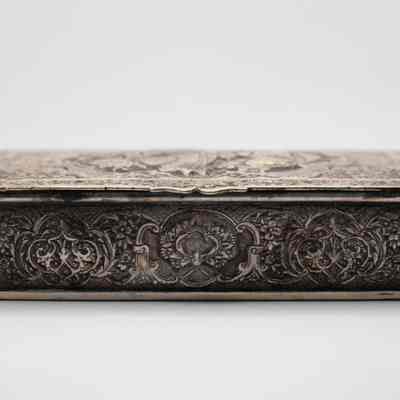 Side of silver repousse box from Persia.: Up close image of the side of the silver repousse box. The box is intricately decorated with Middle Easter-style swirls and leaves.