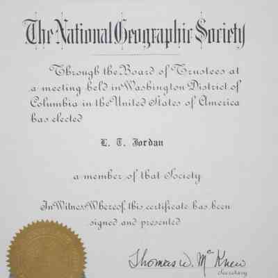 Text on Certificate: Close-up image of the certificate. The top of the certificate is in a stylized script and it is from "The National Geographic Society." The rest of the text is in a celtic script and it reads "Through the Board of Trustees at a meeting held in Washington District of Columbia in the United States of America has elected L.T. Jordan a member of that society In Witness Whereof this certificate has been signed and presented." It is signed by Thomas W. McKnew, the Secretary of the National Geographic Society. It is dated January 1, 1956.