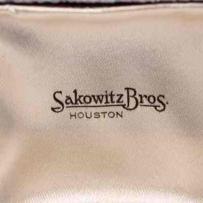 Inside lid of case: Beige silky fabric with "Sakowitz Bros. Houston" printed on it.