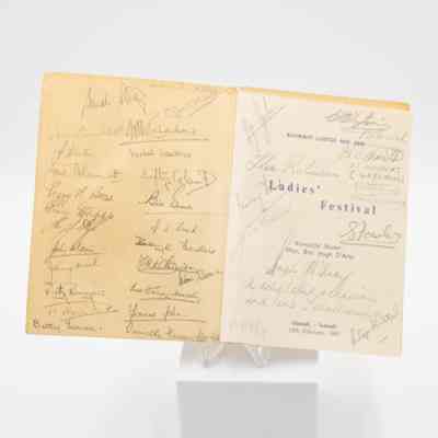 Inside the front cover of the program from the 1961 Ladies' Festival at the Kuwait Masonic Lodge No. 6810.: Image of the inside front cover of the program signed with the names of attendees in black ink. The inside cover is yellowed and the front page is lighter yellow and has blue text on it. The text reads "KUWAIT LODGE No. 6810 LADIES' FESTIVAL, Worshipful Master: War. Bro. Hugh D'Arcy, Ahmadi, - Kuwait, 15th February, 1961."