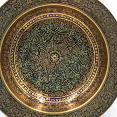 Brass ashtrays with designs: The image shows a brass ashtray featuring intricate black floral motifs, beautifully arranged in an ornate, symmetrical pattern.