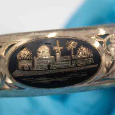 Engraved town scene on the silver cuff bracelet.: Up close image of the engraved Arab town scene on the silver cuff bracelet.