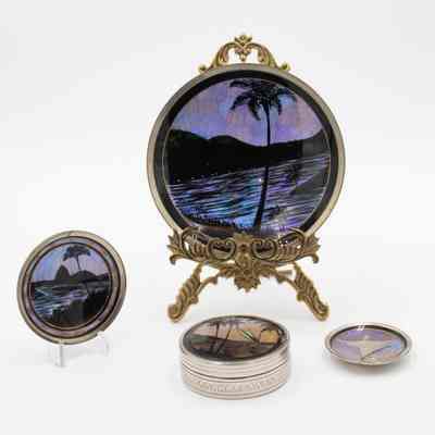 Oasis scene plates and coasters: The image shows decorative plates and coasters with oasis scenes, colored using butterfly wings, featuring palms and water.