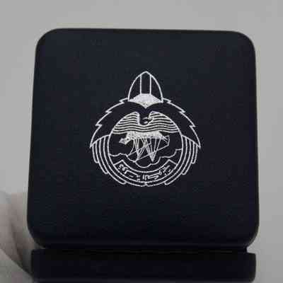 Top of Box: Image of the blue box's top. In the middle is a print of the Emblem of Kuwait in white.