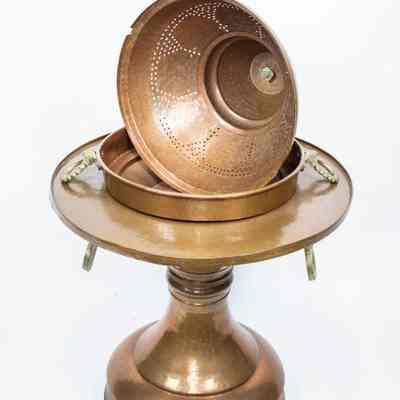 Large brazier: The image shows a large copper brazier with a domed cover, featuring intricate perforated patterns, prominently displayed on a sturdy pedestal base.
