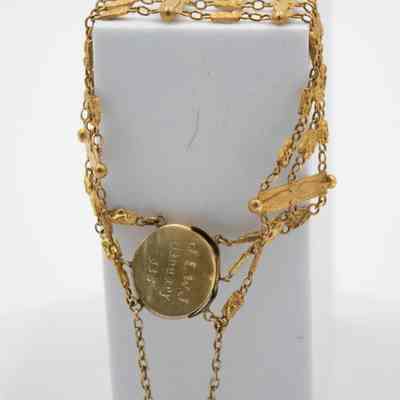 Engraving on the back of the gold floral locket.: Image of the back of the gold floral locket engraved with "J.L.W.J. January 1936."
