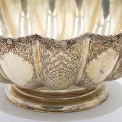 Side of the small sterling silver scalloped serving bowel with engravings of vines and swirls.: Up close image of the scalloped sterling silver serving ball engraved with vines and swirl designs.