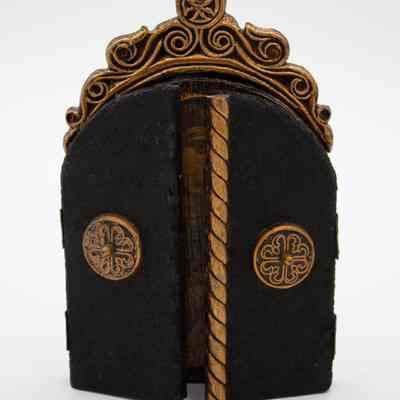 Closed doors of triptych: Image of the triptych with its doors closed. The doors are covered in a black fur. There is a handle in the middle of each door. The handles of the doors are wooden crosses with small wooden knobs in the middle of each.