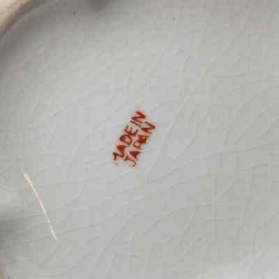 Bottom of the painted Japanese porcelain vase.: Up close image of the bottom of the porcelain vase. It is stamped with "MADE IN JAPAN" in red letters.