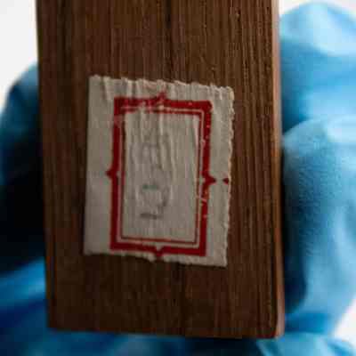 Label on bottom of figure: A white and red label with aged, illegible writing.