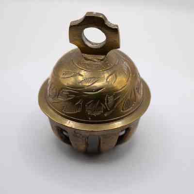 Claw bell: The brass floral elephant claw prayer bell displays engraved leaf patterns above.