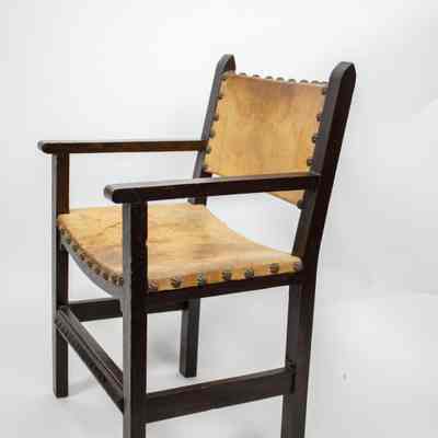 Chair: A wooden chair features a leather seat and back with decorative stud accents.