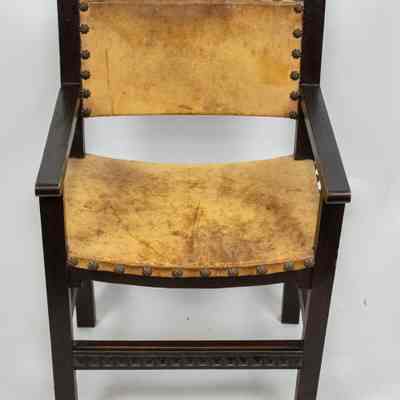 Chair seat and back: The image shows a vintage wooden chair with a worn leather seat and backrest, featuring stud detailing.