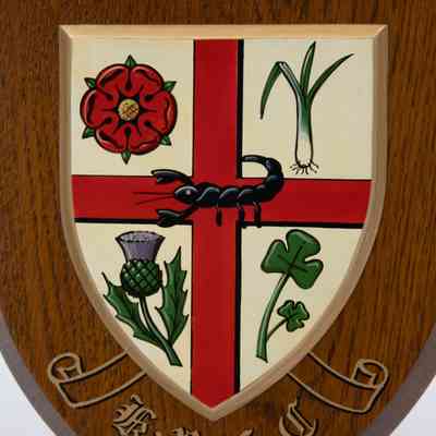K.R.F.D Field Hockey Plaque: The image shows a wooden shield-shaped plaque with the K.R.F.D Kuwait Field Hockey Club crest, featuring a red cross, scorpion, red rose, thistle, leek, and shamrock. In blackletter font, "K.R.F.D"