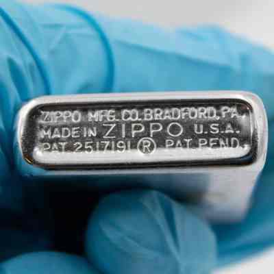 Bottom of lighter: Steel lighter bottom engraved with "ZIPPO MFG. CO. BRADFORD, PA. MADE IN USA. ZIPPO PAT 2517191. PAT PEND."