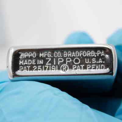 Bottom of lighter: Steel lighter bottom engraved with "ZIPPO MFG. CO. BRADFORD, PA. MADE IN USA. ZIPPO PAT 2517191. PAT PEND."