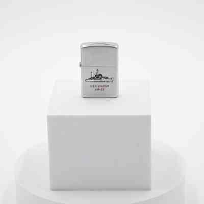 U.S.S Valcour Zippo: The steel lighter has a black engraved photo of the U.S.S Valcour. In gold letters the ship is labeled with "AVP-55" on the bow. In red writing underneath the ship it says "U.S.S Valcour AVP-55."