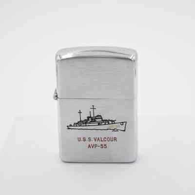 U.S.S Valcour Zippo: The steel lighter has a black engraved photo of the U.S.S Valcour. In gold letters the ship is labeled with "AVP-55" on the bow. In red writing underneath the ship it says "U.S.S Valcour AVP-55."