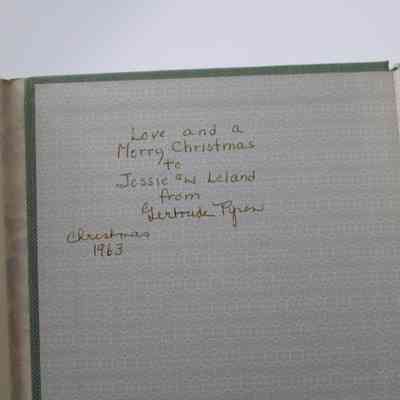 Inside Signature: Inside “Flowers of the Holy Land” is writing in yellow ink. It reads "Love and a Merry Christmas to Jessie and Leland from Gertrude Pyron Christmas 1963."
