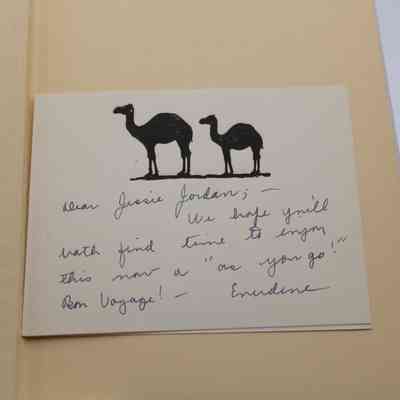 Inside Note: Inside “Fly with Me to India" is a small note with two camels stamped on it. Below the camels is some writing in black ink which reads "Dear Jessie Jordan; - We hope you'll hath find time to enjoy this mom a 'as you go!' Bon Voyage! - Evendine"