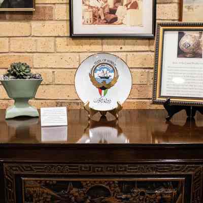 Top of bar, decorated: The carved wooden bar showcases intricate details, supporting a decorative plate and potted plant.