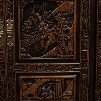 Panel of wooden bar: The carved wooden Hong Kong bar showcases intricate scenes of traditional landscapes and architecture.