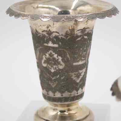 One of the five-inch silver vases engraved with floral motifs.: Up close image of one of two five-inch silver vases engraved with floral motifs and a flared rim.