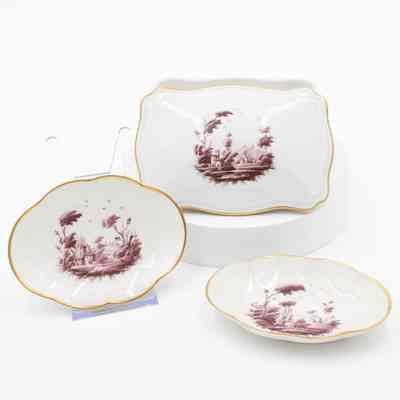 Ashtrays and box: The image shows white ceramic ashtrays and a cigarette box, painted with a burgundy pastoral scene and gold rims.