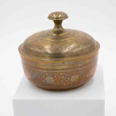 Brass covered bowl: The image shows a small brass-covered bowl with an engraved red floral motif.