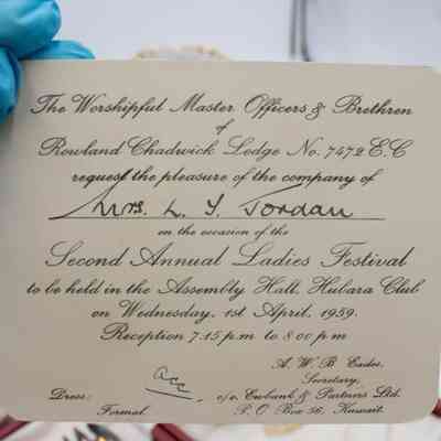 Invitation to the Second Annual Ladies Festival addressed to Mrs. Jessie Jordan.: Image of the cream-colored invitation with black cursive text. The invitation reads "The Worshipful Master Officers of Brethren of Rowland Chadwick Lodge No. 7472 E.C. request the pleasure of the company of Mrs. L.T. Jordan on the occasion of the Second Annual Ladies Festival to be held in the Assembly Hall, Hubara Club on Wednesday, 1st April, 1959. Reception 7:45 p.m. to 8 p.m." in the center. In the bottom left, it reads "Dress: Formal" and in the bottom right, it reads "A.W.B Eades, Secretary, c/o. Eubank & Partners Ltd., P.O Box 56, Kuwait."
