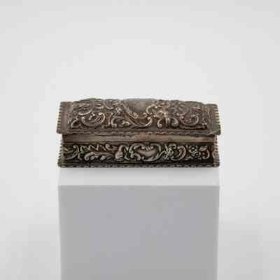 Small pressed silver-plated rectangular box.: Image of the small silver rectangular box embossed with a leaf swirl design.