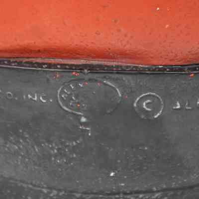 Alexander Backer logo: Close up image of the back of the black base. The words "CO. INC. © ALEXANDER" are visible in this image. What could be the logo for the original maker of this Buddha, Alexander Backer, is between the Inc. and copyright symbol, although much of it is illegible. Only "Alex" is able to be made out.