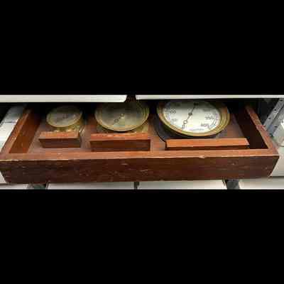 Brass steam gauges mounted on display board.