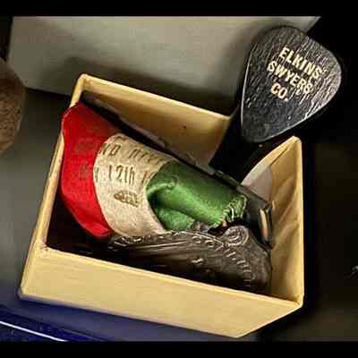Small box holding rubber stamp and award medal.