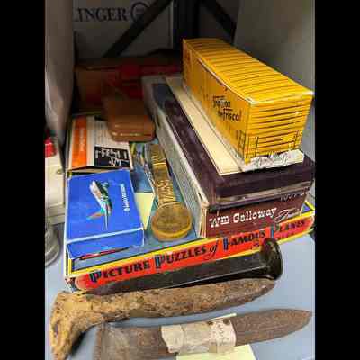 Misc artifacts: Large box of matches made to look like a yellow Frisco rail car; box of playing cards from America West Airlines; box labelled “Picture Puzzle of Famous Planes,” etc.
