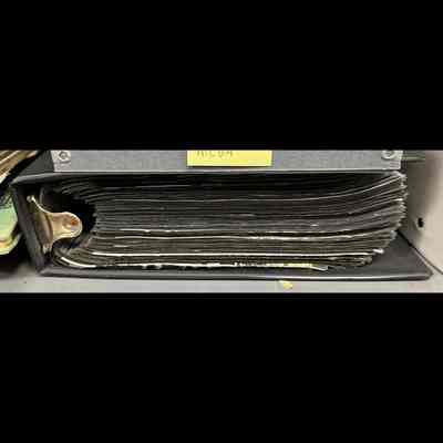 3-ring binder with page protectors carrying paper ephemera.