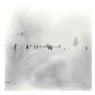 People swimming and boats