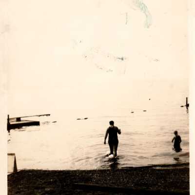 Alki beach with man and child in water.