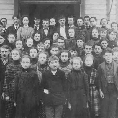 Photograph of children posed outside school, circa early 1900s.