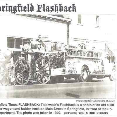 Photograph of old pumper wagon from 1888 and white fire truck, on Main Street, Springfield, Oregon, 1949.
