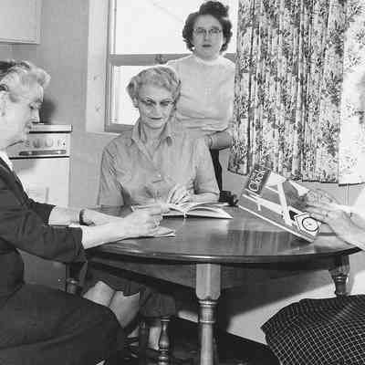 Photograph of ladies reading magazines, date unknown