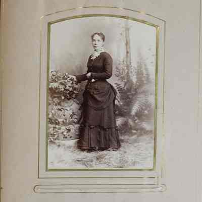 2016-024-012_img-005: Page 3 of photograph album 2016.024.012: Unknown woman in a long sleeve dress standing .